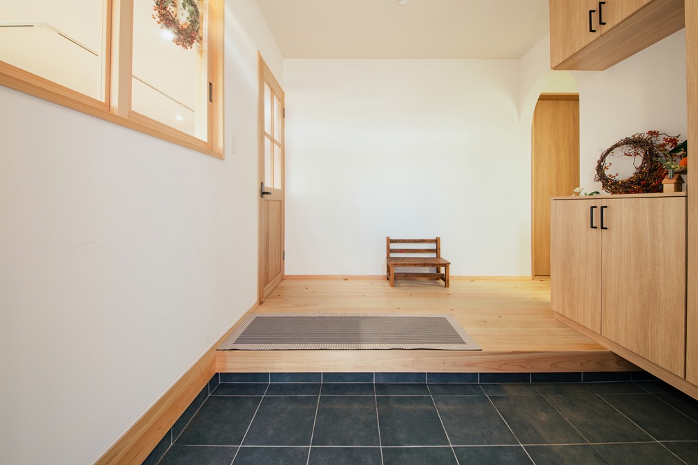 造作のリビングドアと小窓が目を惹くスッキリとした玄関