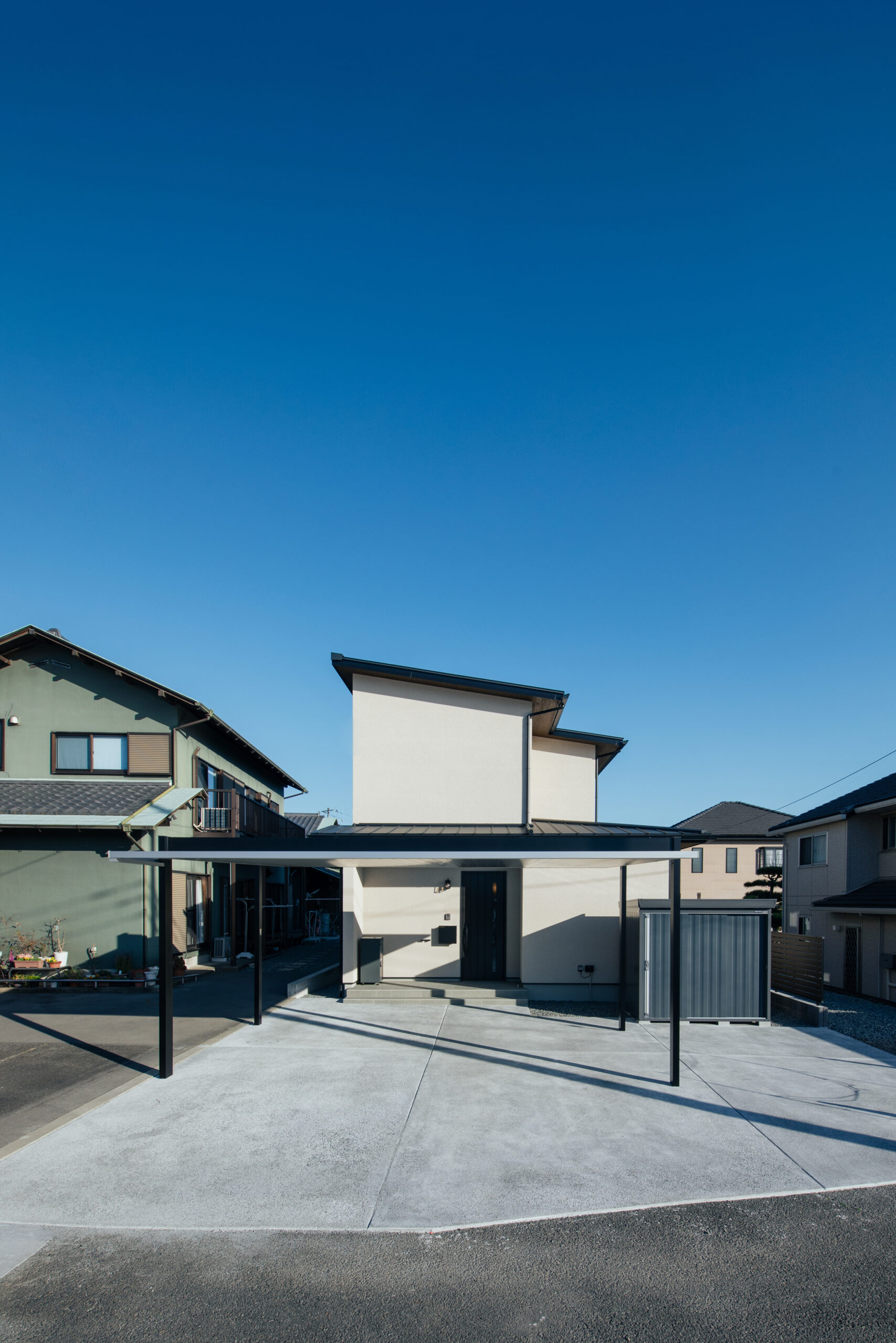 やわらかなベージュの塗り壁風に、ブラックのフレームが空間を引き締める外観