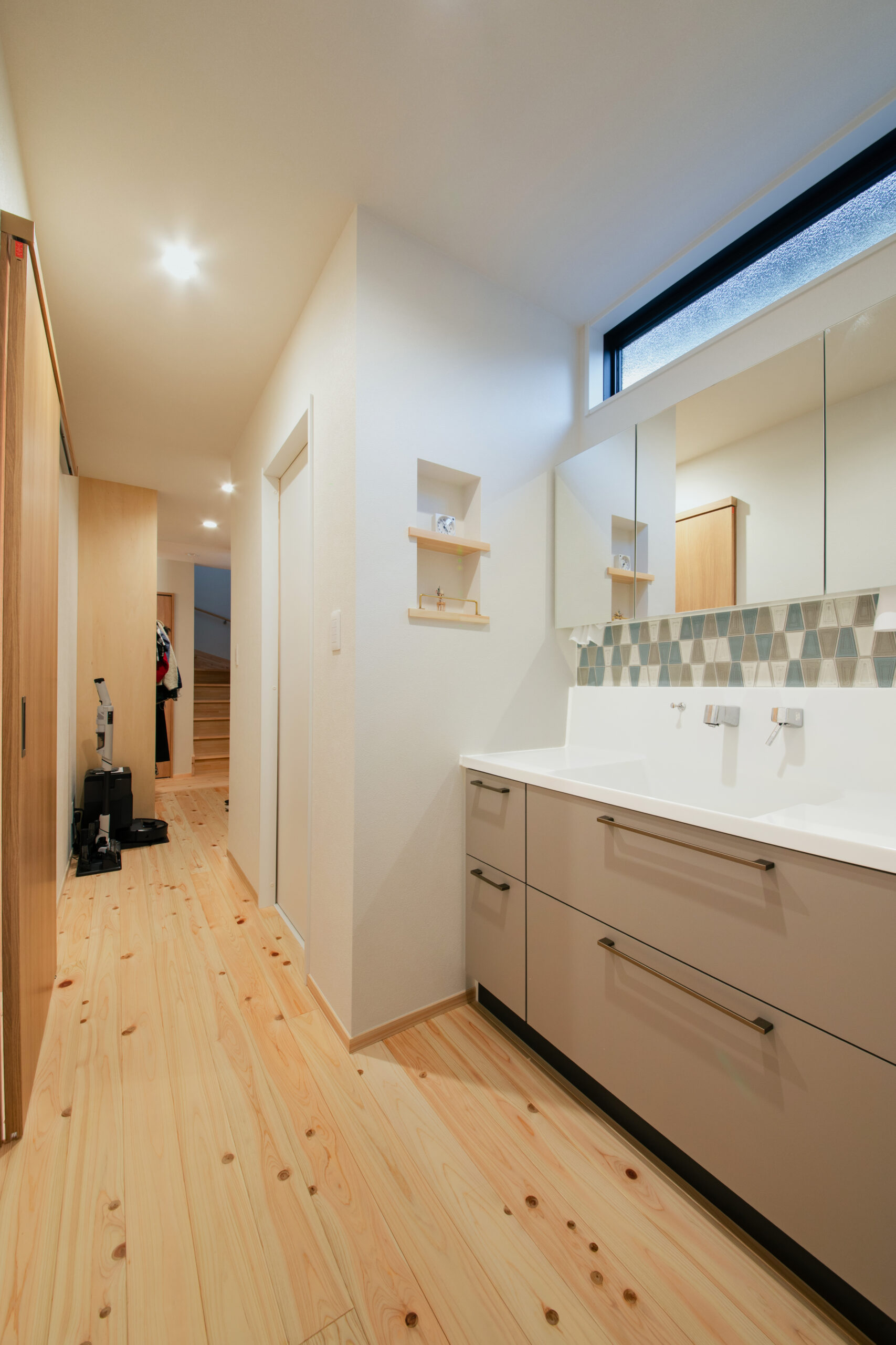 お気に入りのタイルを張っった洗面台。奥にランドリールームとお風呂が一直線でつながっているので、忙しい日々の家事も１か所で完結。